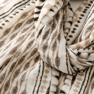 Detail of bohemian geometric print scarf showing soft fabric texture and fringe trim