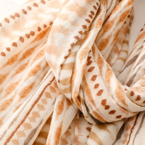 Detailed view of bohemian style scarf with warm geometric patterns and soft cotton linen texture