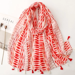 Close-up of red and white geometric wave pattern scarf with stylish tassel details