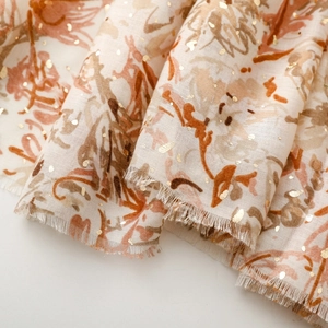 Vue détaillée de l'écharpe fleurie beige avec pois dorés et bordures effilochées