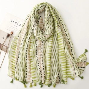 Detail of thin geometric striped scarf with green tassels and light cotton linen texture