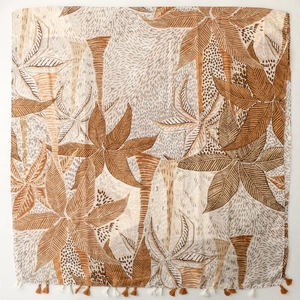 Detail of tropical palm leaf print scarf with coffee and white fringe tassels