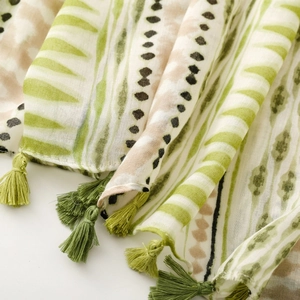 Macro detail of geometric patterned cotton scarf with bohemian green fringe tassels