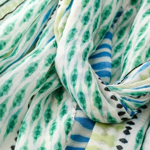 Macro shot of abstract geometric print on soft cotton linen scarf with blue and green hues
