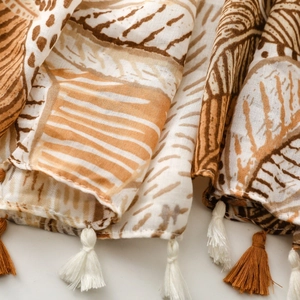 Close-up of tropical palm leaf print scarf with elegant brown and white fringe tassels