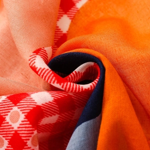 Close-up of lightweight plaid scarf fabric with red white grid and colorful patterns