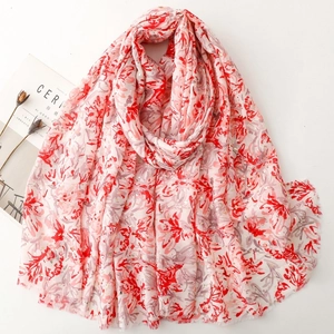 Détail d'écharpe en coton et lin avec motif floral rouge et accents dorés brillants