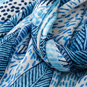 Detail of blue and white abstract tropical palm leaf print on lightweight summer scarf