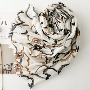 Detail of soft scarf with gold heart print, abstract rings, and frayed edge trim