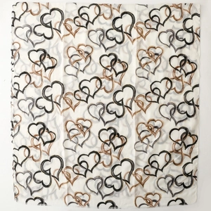 Detail of soft scarf featuring repeating black and brown abstract heart prints