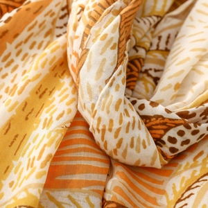 Macro view of lightweight palm tree print shawl showing textured fabric and warm tones