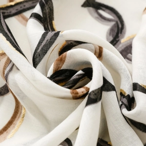 Detailed macro view of soft linen-feel scarf with gold foil heart pattern and flowy texture
