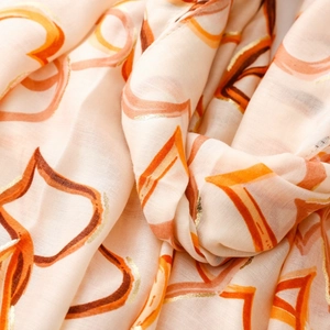 Macro shot of cotton linen scarf featuring gold foil hearts and intricate draped texture