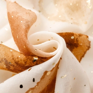 Détail du tissu d'écharpe léger avec pois dorés et motif délavé à l'encre marron