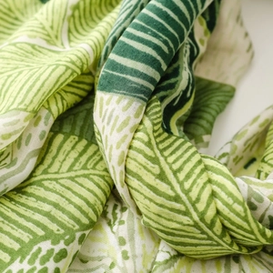 Close-up of tropical green palm leaf print scarf showing breathable soft fabric texture