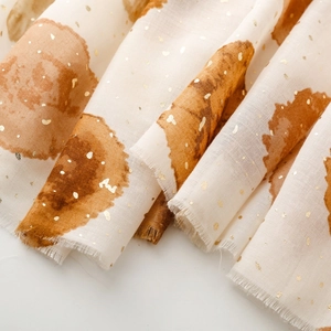 Détail d'écharpe beige avec dorure à la feuille, pois aquarelle et bords effilochés