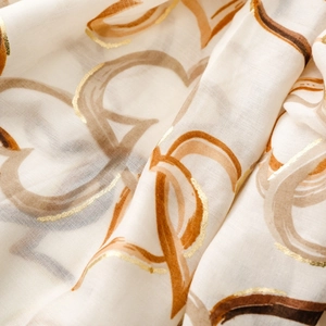 Detail of cotton linen scarf featuring gold foil heart prints and woven texture