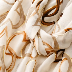 Detailed view of lightweight linen scarf with gold foil heart print and soft draping texture
