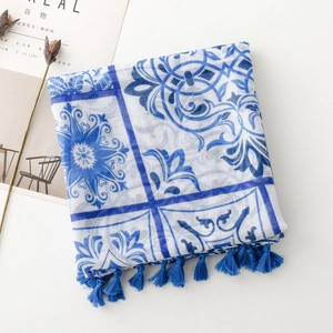 Détail d'une écharpe à motif porcelaine bleue et blanche avec des pompons élégants