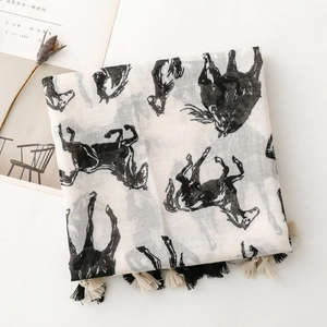 Détail des glands tissés sur une écharpe en coton et lin avec motif de cheval noir