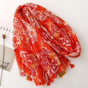 Bohemian floral scarf in orange with tassels, styled with a minimalist magazine