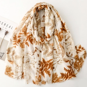 Linen feel scarf with orange maple leaf print and fringe edges on cream background