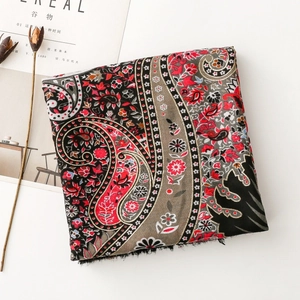 Detail of vintage bohemian scarf with red paisley floral print and fringe edges