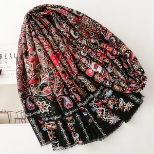 Detail of ethnic paisley shawl with floral patterns, tassels and lifestyle magazine prop