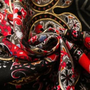 Close-up of bohemian paisley floral pattern with golden metallic thread weaving