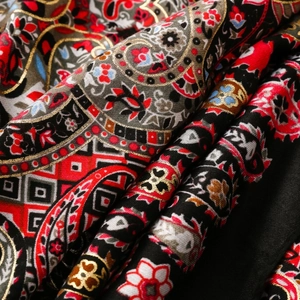 Close-up of ethnic paisley pattern scarf with gold embroidery and floral details