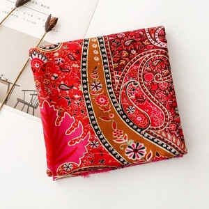 Detailed view of red bohemian paisley scarf with floral patterns and frayed edges