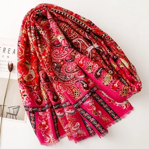 Detail of red paisley bohemian scarf with floral patterns and soft fringe tassels