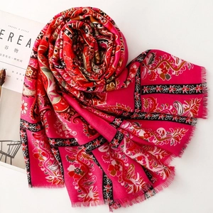 Close-up of pink paisley floral scarf with golden prints and delicate fringe edges