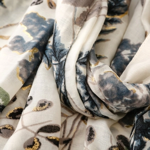 Macro shot of cotton linen scarf with blue floral print and gold foil leaf detailing