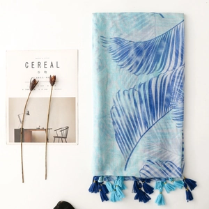 Macro detail of tropical palm leaf pattern scarf with blue tassel fringe decoration
