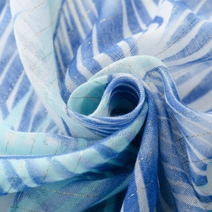 Macro shot of blue and white silk scarf fabric with golden lurex metallic thread