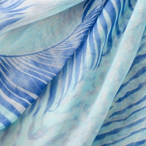 Detail of blue palm leaf print fabric with woven gold metallic threads and soft texture