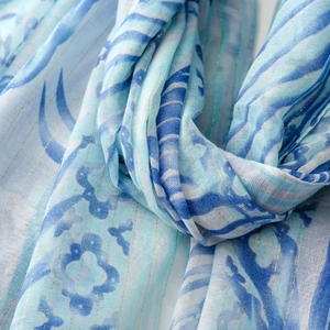 Detail of blue printed scarf with gold metallic threads and soft tassel texture