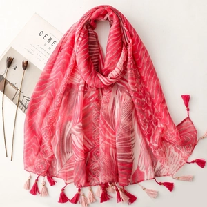Close-up of pink floral scarf showing gold silk stripes and decorative edge tassels