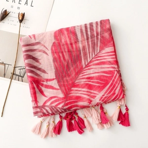Detail of pink tropical palm leaf print scarf with long tassel edge and fringe accents