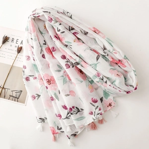 White floral cotton linen scarf with pink blossoms and elegant tassels on plain background