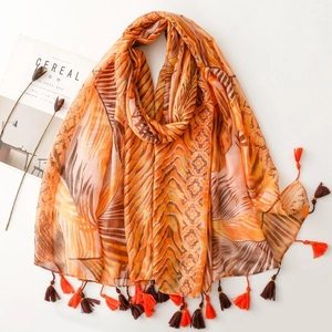 Detail of tropical palm leaf print scarf with elegant fringe and magazine styling