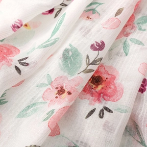 Detailed macro of white cotton-linen scarf fabric with pink floral patterns and silver threads