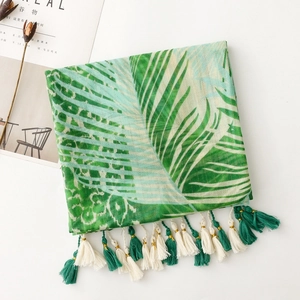 Detail of summer scarf with tropical palm leaves, leopard print, and tassel fringe edge