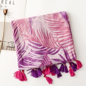 Detail of bohemian scarf featuring tropical palm leaf print and soft handmade tassels