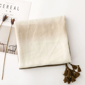 Detail of cotton linen scarf with elegant fringe tassels and two-tone color transition