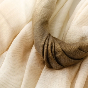 Macro detail of champagne cotton-linen scarf with shimmering silver silk and soft texture