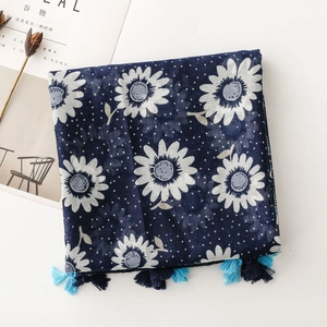 Navy blue scarf with white daisy print and bohemian tassels on a white background