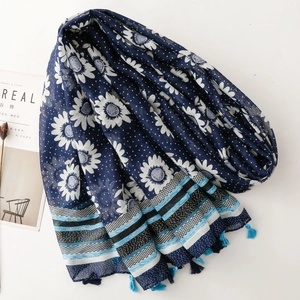 Detail of dark blue scarf with white sunflower print, dots, and elegant fringe tassels