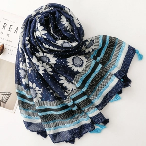 Ethnic navy blue scarf with sunflower print and light blue tassels on a flat lay view